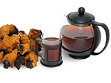 Chaga drink in a coffee pot with chaga pieces next to it